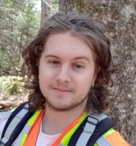 Delbert wearing high viz vest beside a tree